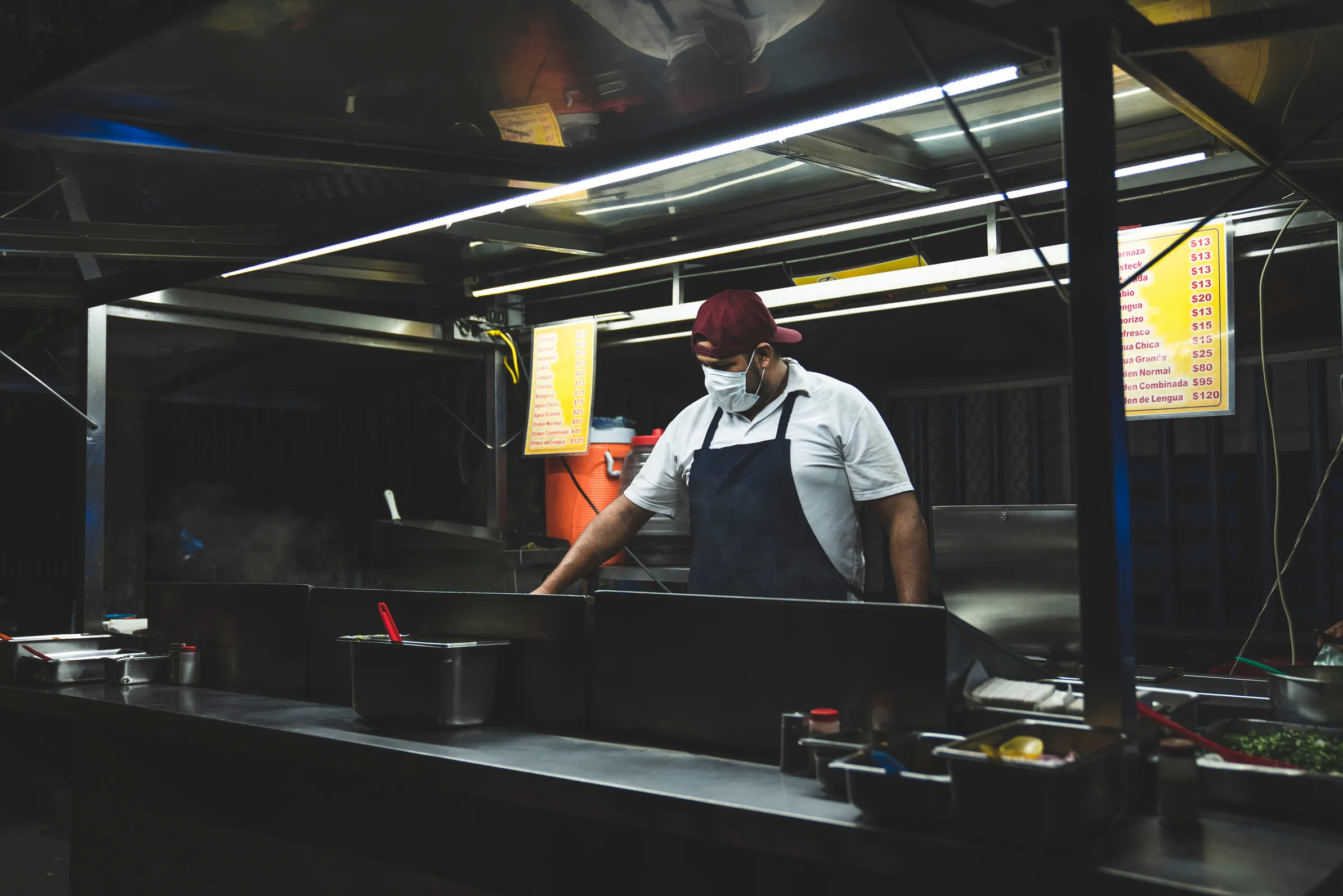 Cocinero trabajando en la plancha de una cocina industrial