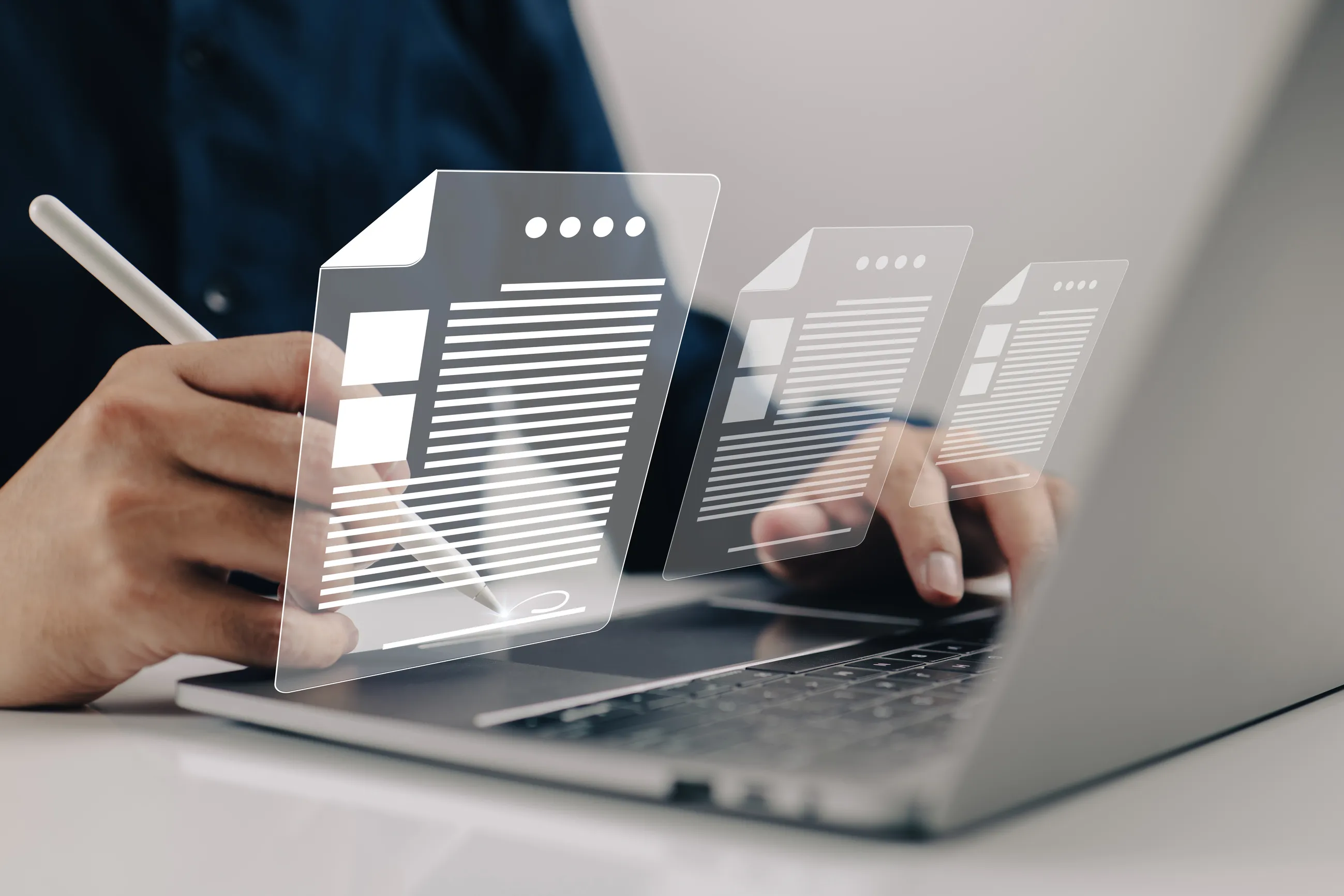 Manos trabajando en una computadora portátil junto a documentos de embarque